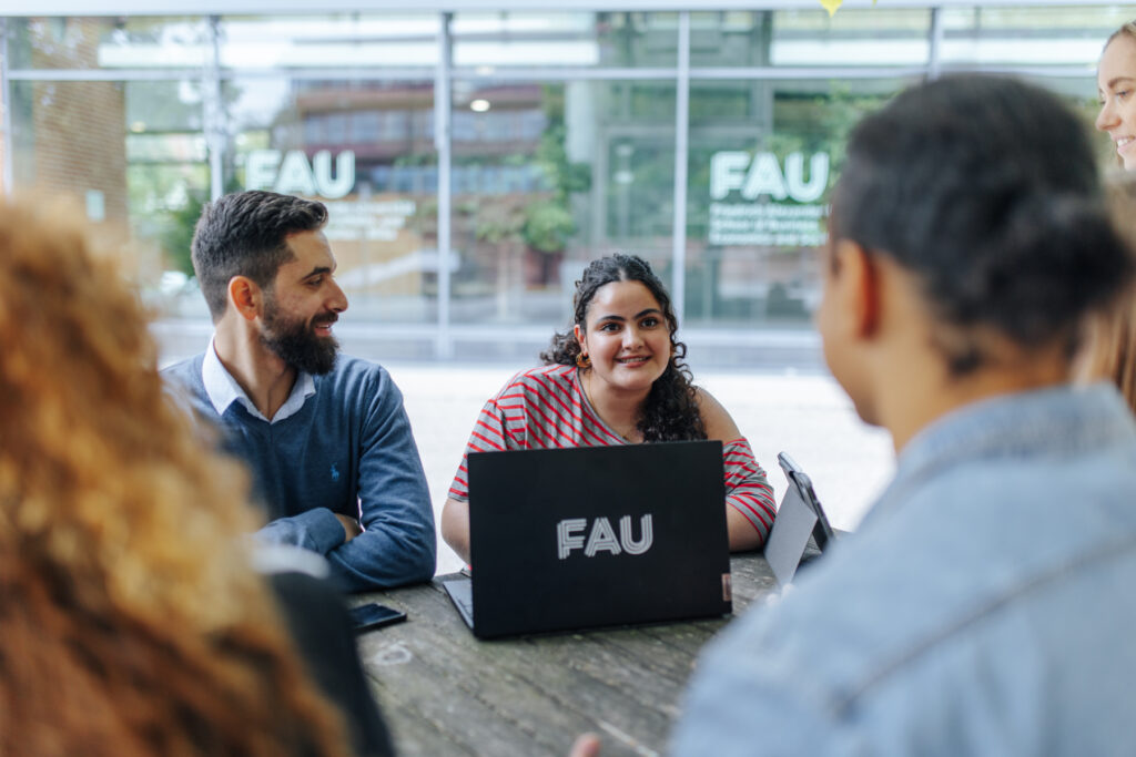 Studierende in einer Besprechung im Innenhof