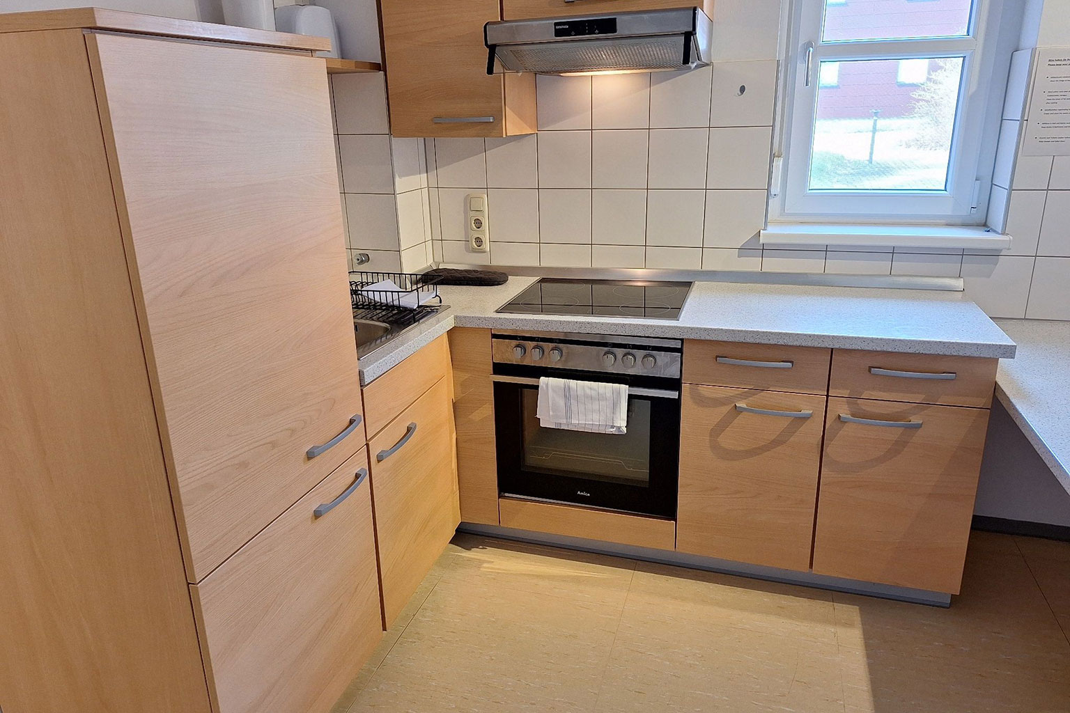 View of a kitchen with stove, oven, work surfaces and cupboards.
