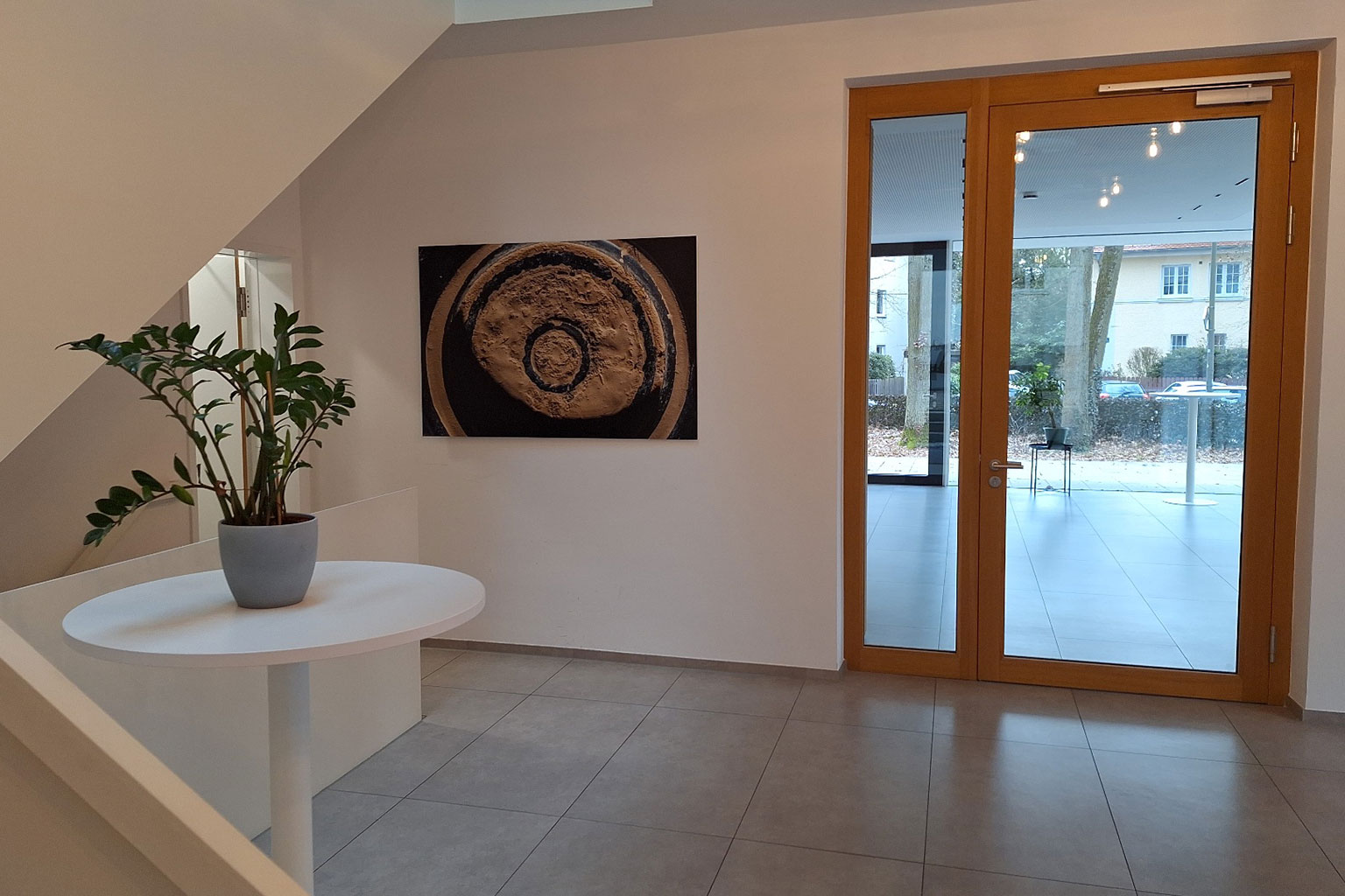 View of a foyer with glass door and paintings on the walls.