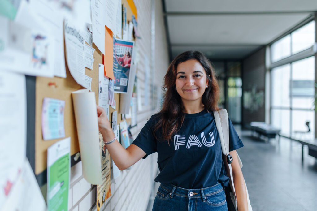 Studentin zeigt auf Pinnwand