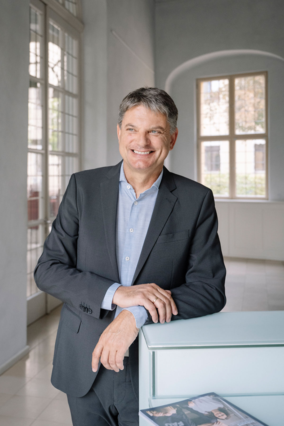 Joachim Hornegger lehnt an einem Tisch.