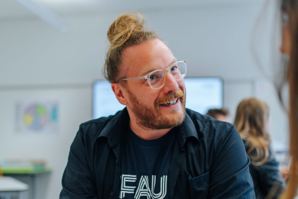 Mann erklärt einer Person hinter der Kamera