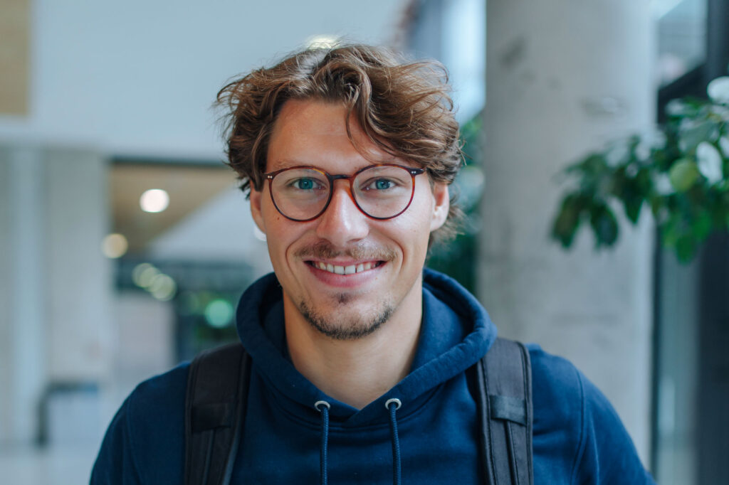 Ein Student grinst in die Kamera.