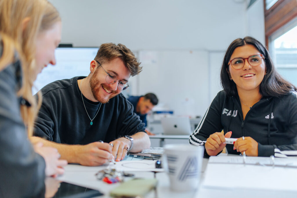 Gruppe von Studierenden sitzt am Tisch und lernt zusammen